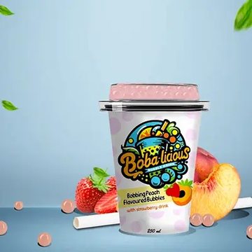 Bobbing Peach Flavoured Bubbles with strawberry drink, accompanied by ripe peaches and strawberries.