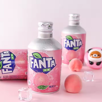Fanta Peach aluminum bottles and cans with pastel pink design, surrounded by fresh peaches and ice cubes.