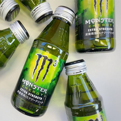 Monster Energy Extra Strength bottles featuring bold green and black design with iconic claw logo.