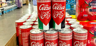 A vibrant display of Cola Gaza cans featuring their iconic red and green design, neatly arranged in a supermarket aisle, highlighting the beverage's cultural significance and availability in retail stores.